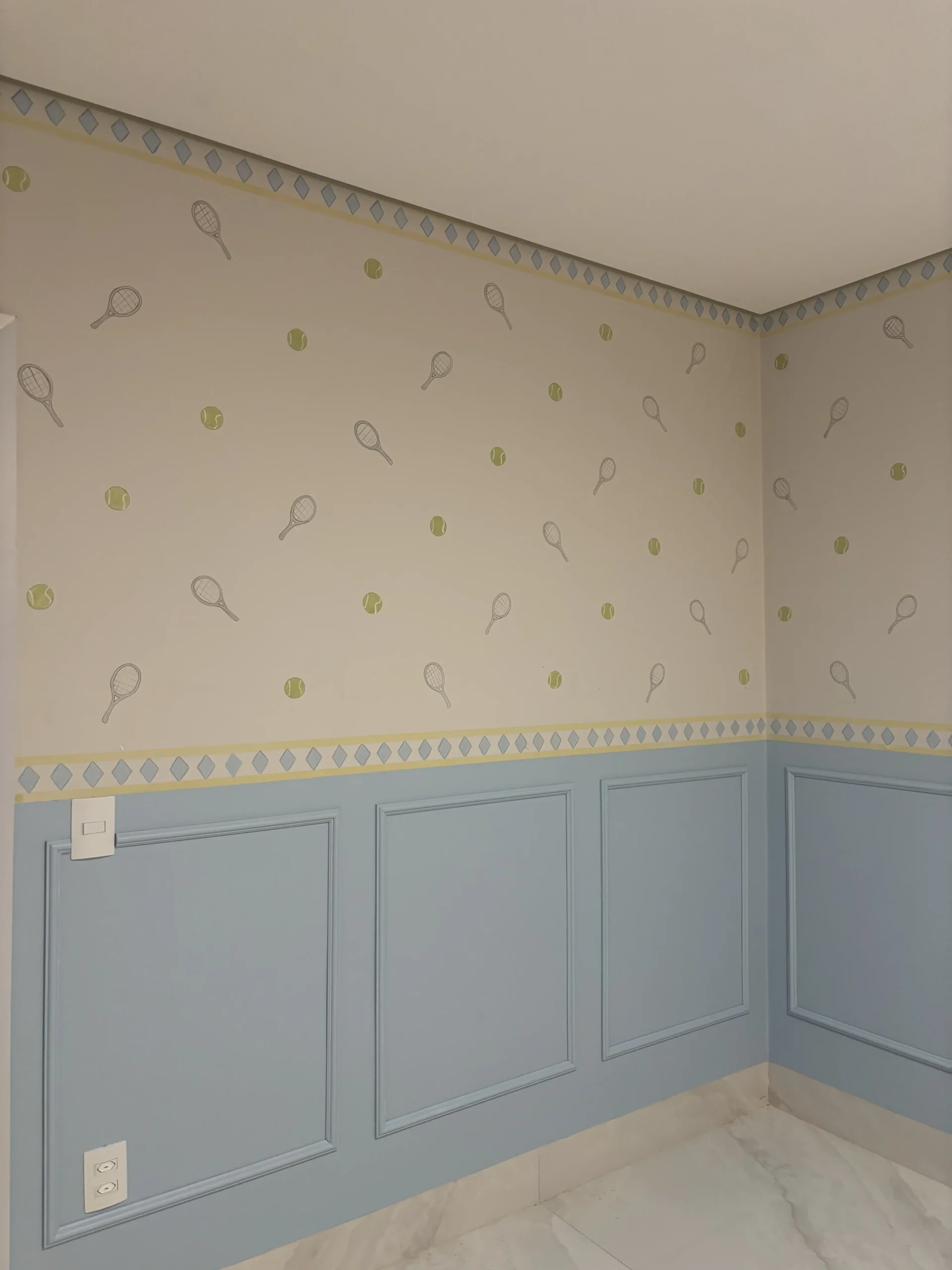Quarto com pequenos desenhos delicados e meia parede azul
