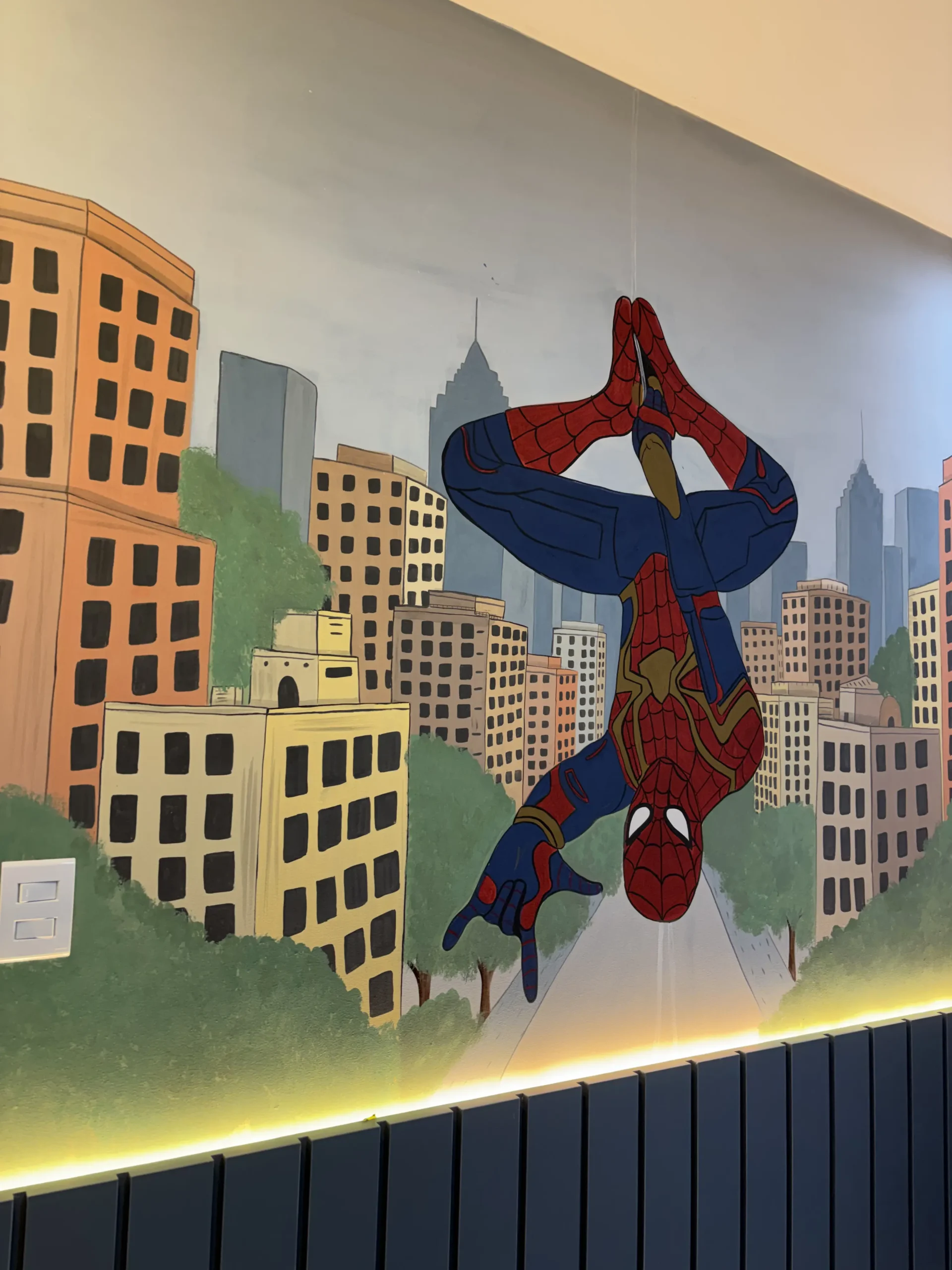 Homem-Aranha pintado sobre uma cidade em um quarto infantil