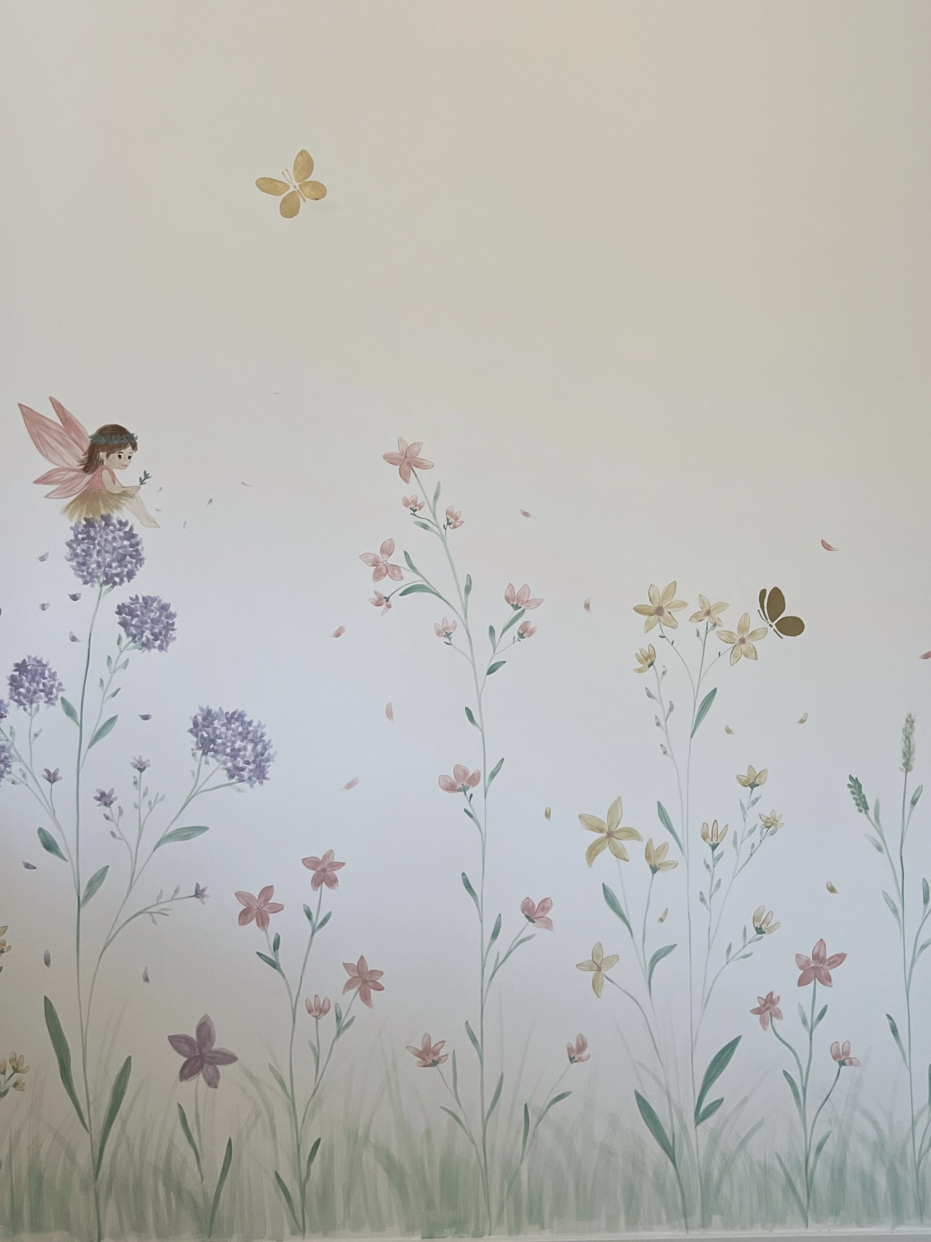 Detalhes de flores lilases, folhagens e borboletas em um mural de Jessica Santos