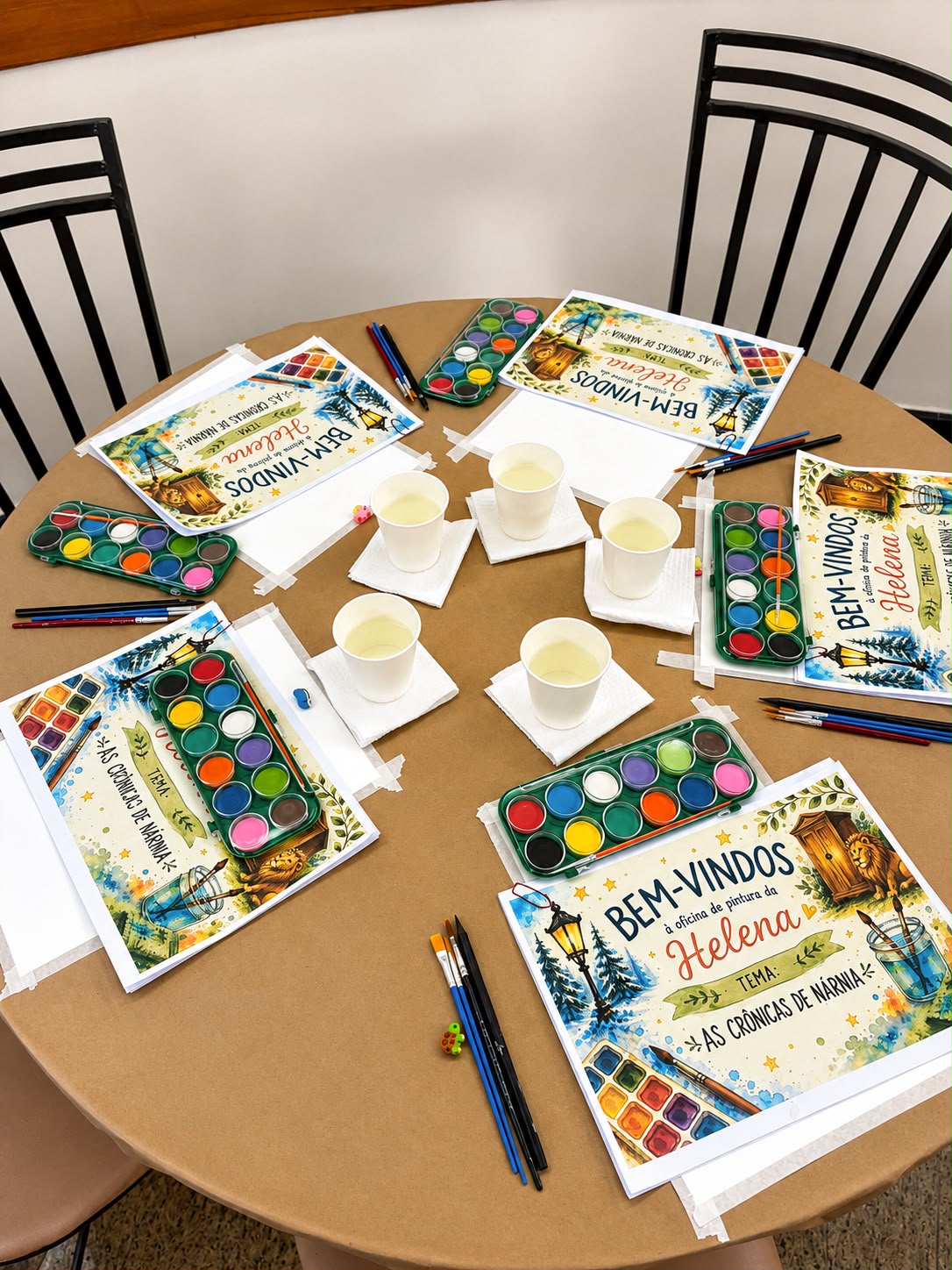 Mesa redonda com kits de aquarela personalizados, um para cada participante